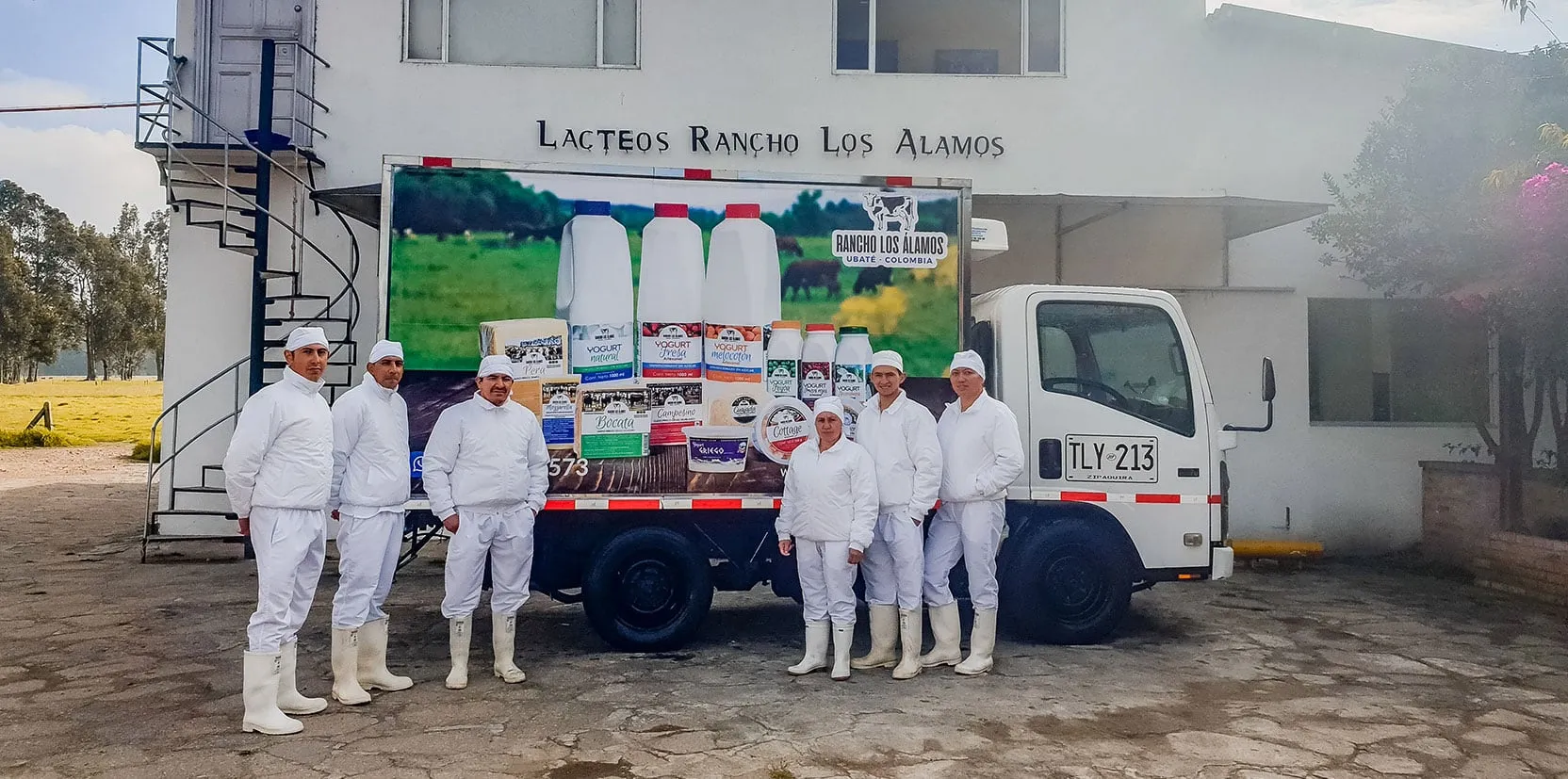 Equipo de Rancho Los Álamos frente a la planta y el camión de reparto, en Ubaté